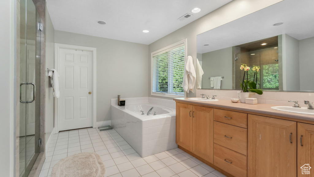 Bathroom featuring a stall shower, a bath, double vanity, tile patterned flooring, and recessed lighting