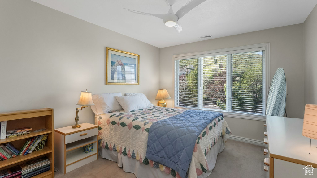 Bedroom featuring baseboards, light colored carpet, and ceiling fan