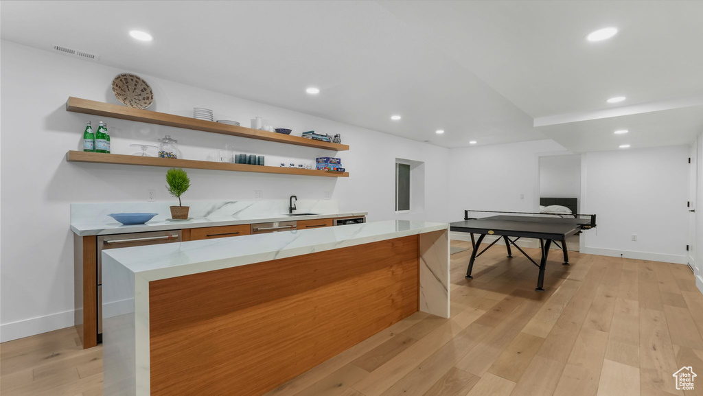 Indoor wet bar featuring light wood finished floors, recessed lighting, baseboards, and stainless steel dishwasher