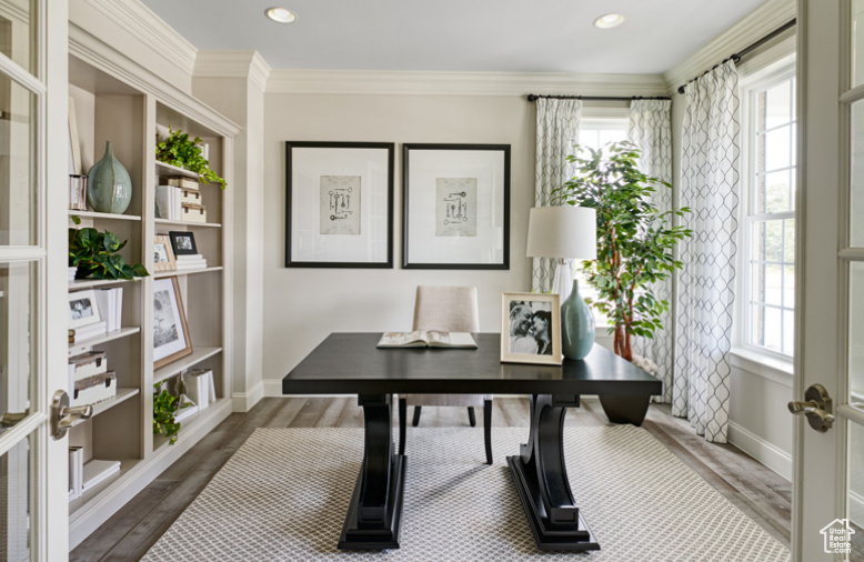 Home office with healthy amount of natural light, wood finished floors, recessed lighting, baseboards, and crown molding