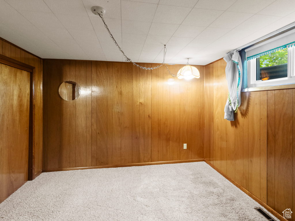 Unfurnished room with carpet flooring and wooden walls