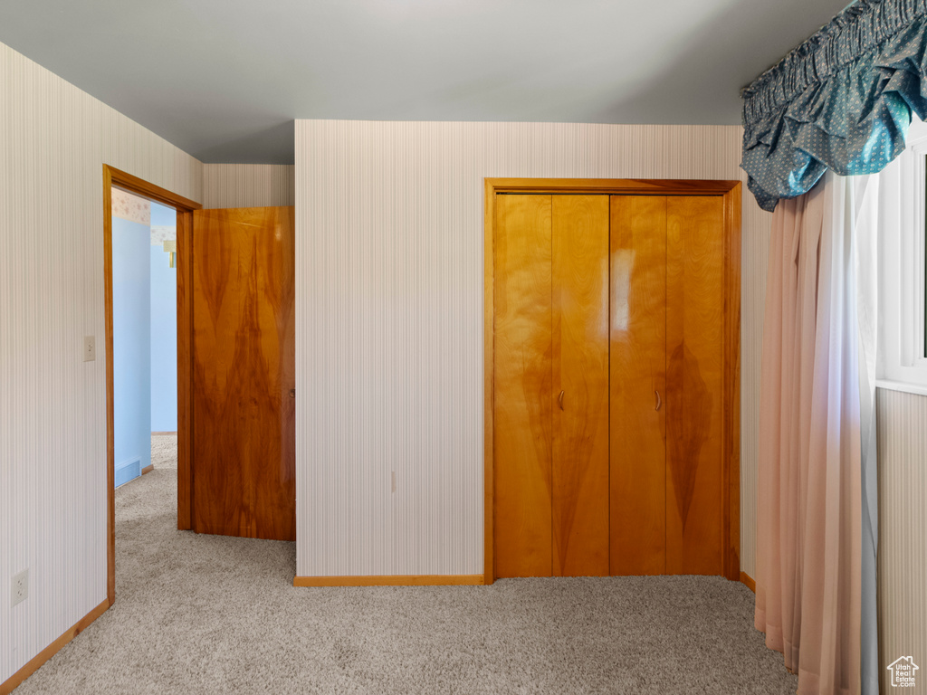 Unfurnished bedroom featuring carpet floors, a closet, and baseboards
