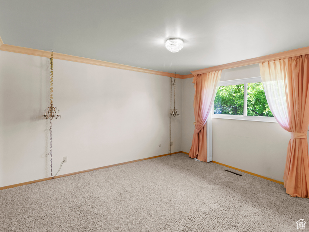 Carpeted empty room featuring baseboards