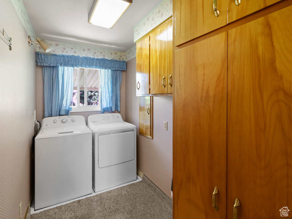 Washroom with washer and clothes dryer, cabinet space, and carpet floors
