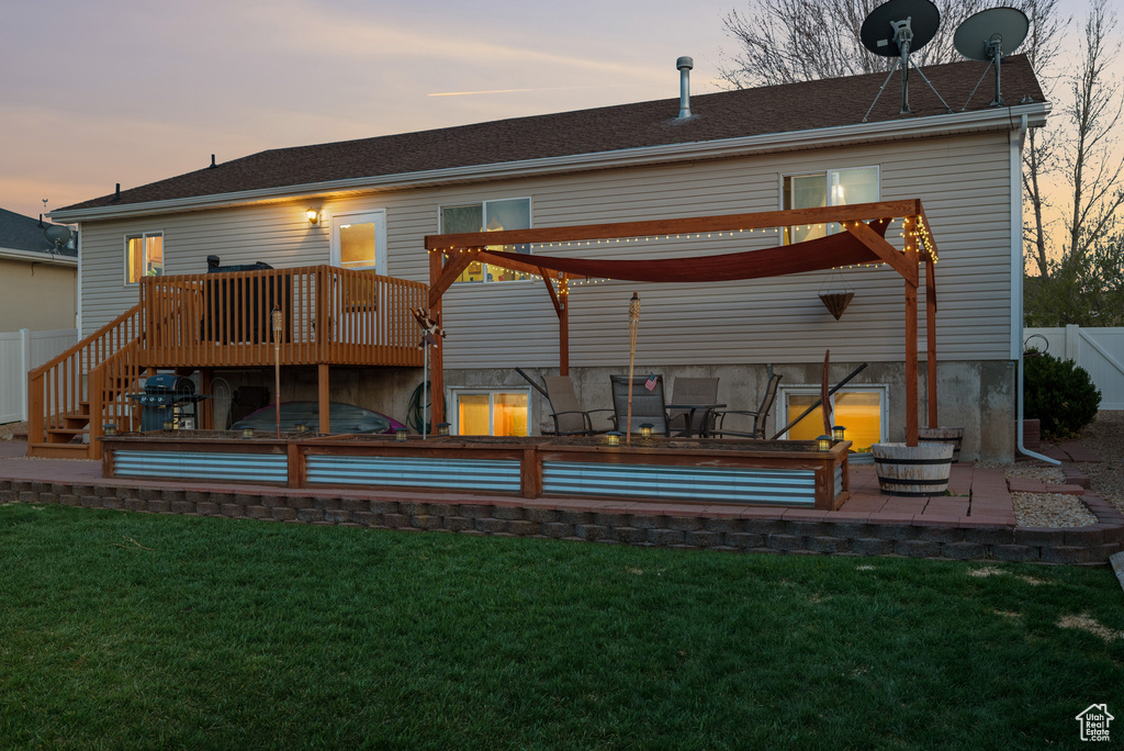 Back of house with a lawn, a deck, a patio, and fence