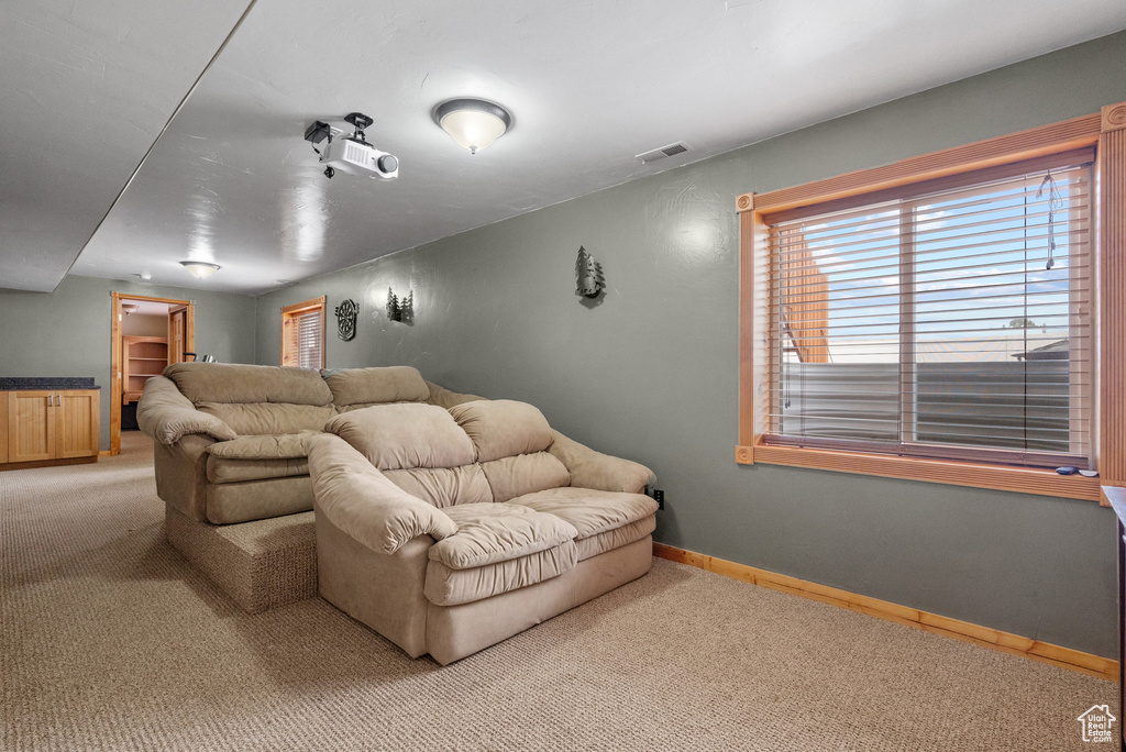 Home theater with visible vents, light colored carpet, and a healthy amount of sunlight