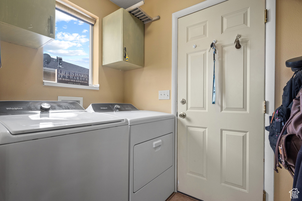 Clothes washing area with cabinet space and separate washer and dryer