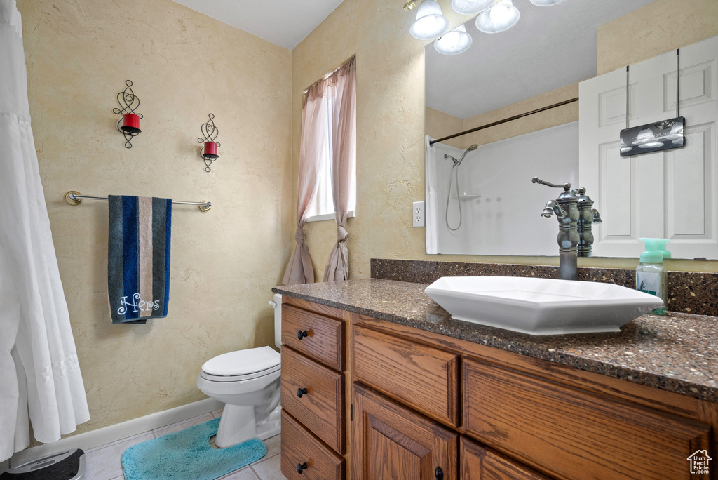 Bathroom featuring curtained shower, baseboards, toilet, tile patterned floors, and vanity