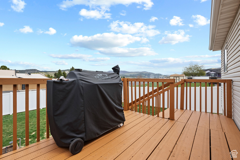 Wooden terrace with a mountain view, a grill, and fence