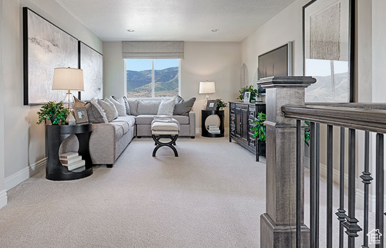 Carpeted living room with baseboards and a textured ceiling