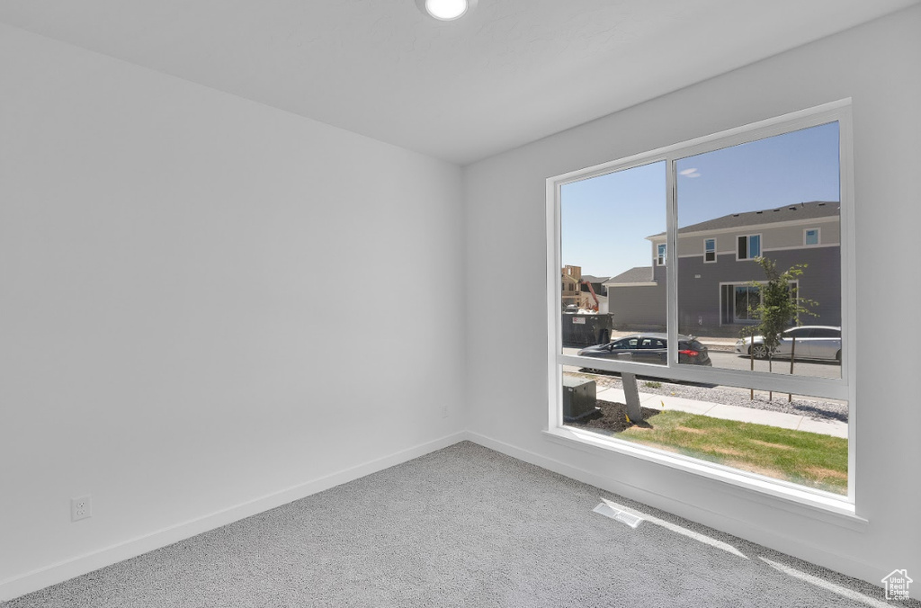 Carpeted empty room with baseboards