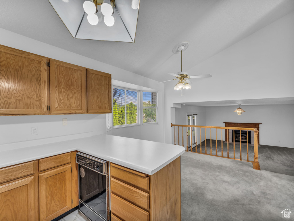Kitchen with a peninsula, black dishwasher, light countertops, lofted ceiling, and ceiling fan