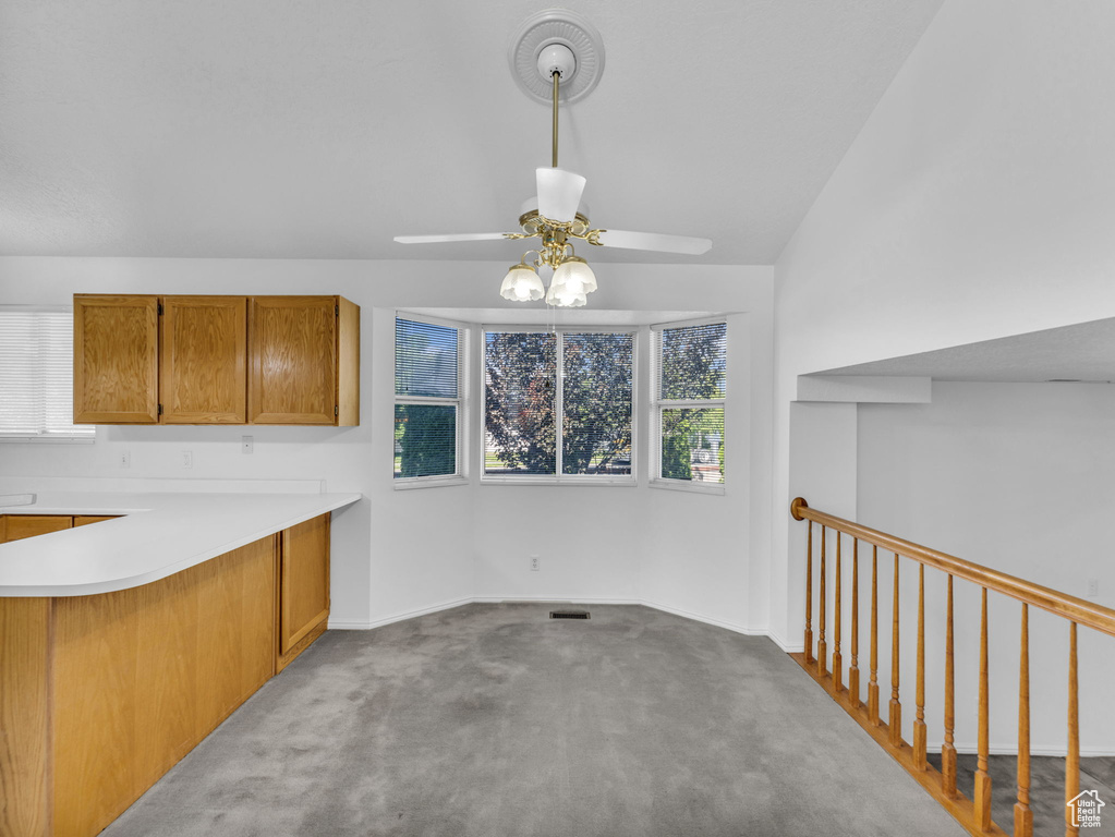 Unfurnished dining area with a ceiling fan, carpet flooring, and baseboards