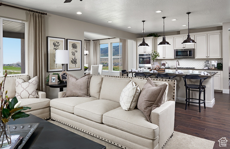 Living area featuring dark wood-type flooring, recessed lighting, and ceiling fan