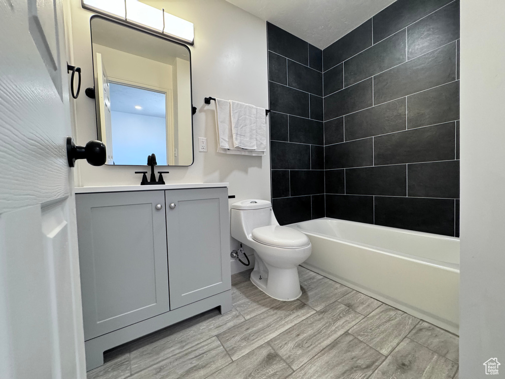 Bathroom featuring toilet, vanity, and washtub / shower combination