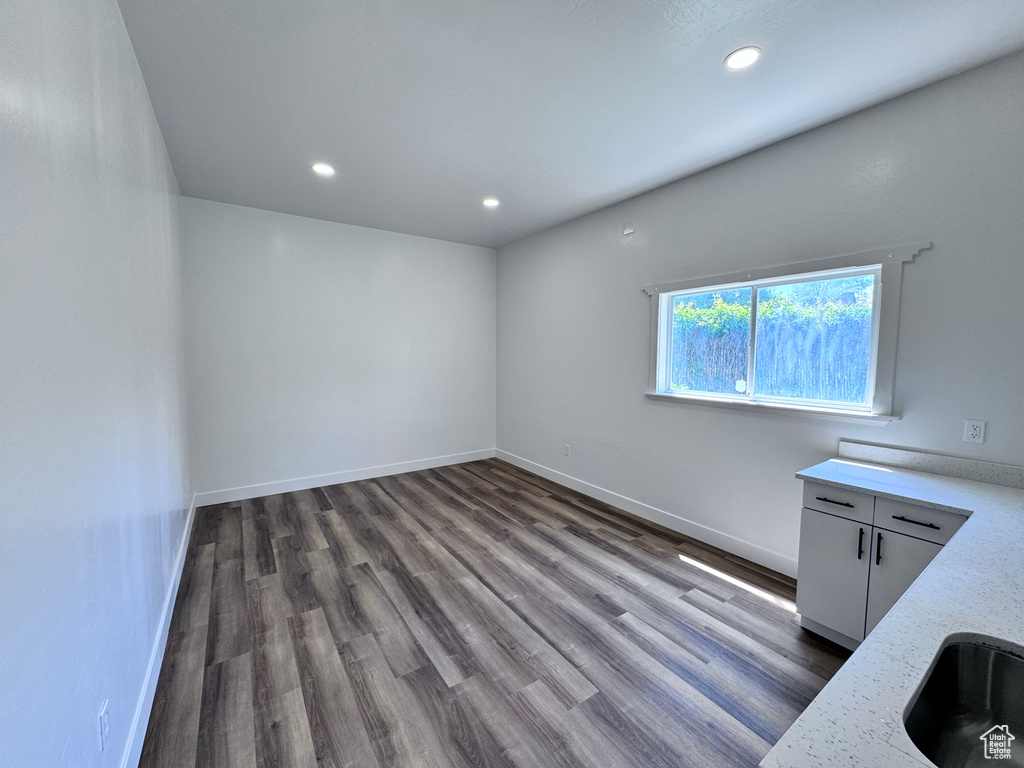 Unfurnished dining area with wood finished floors, recessed lighting, and baseboards