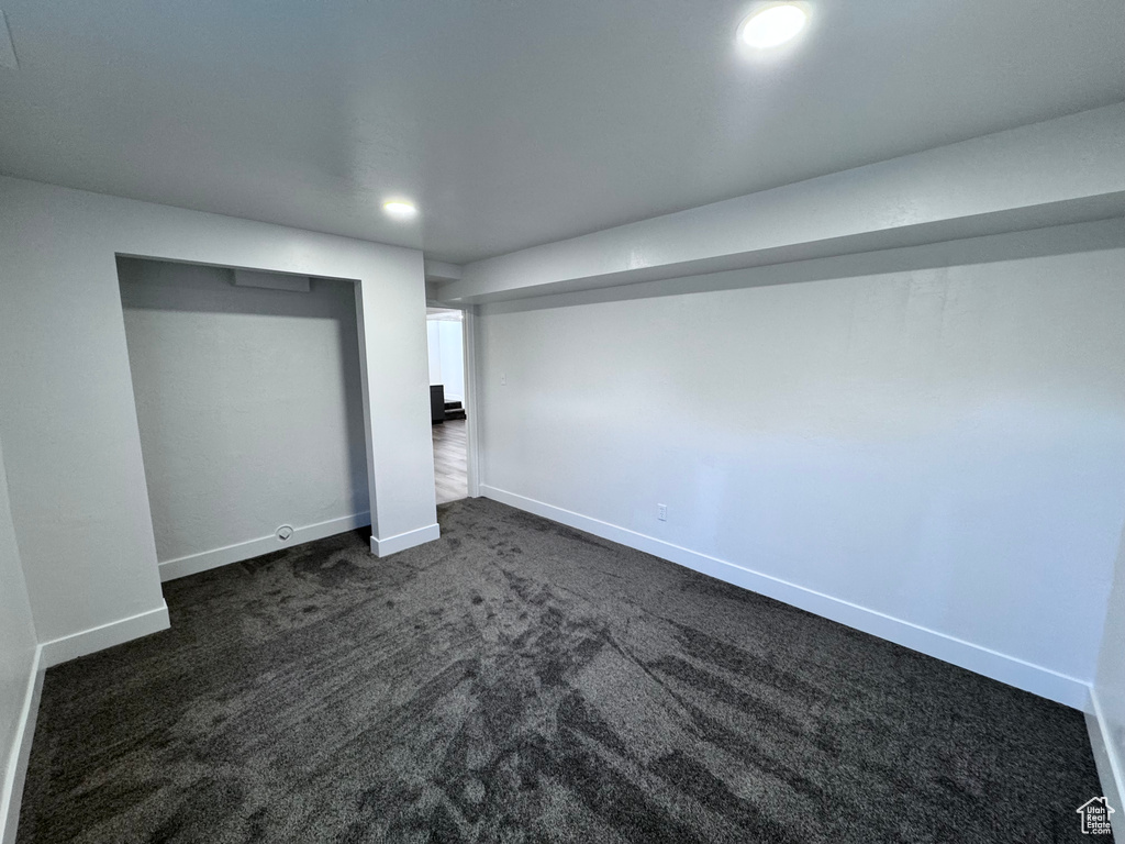Finished basement with dark carpet, baseboards, and recessed lighting