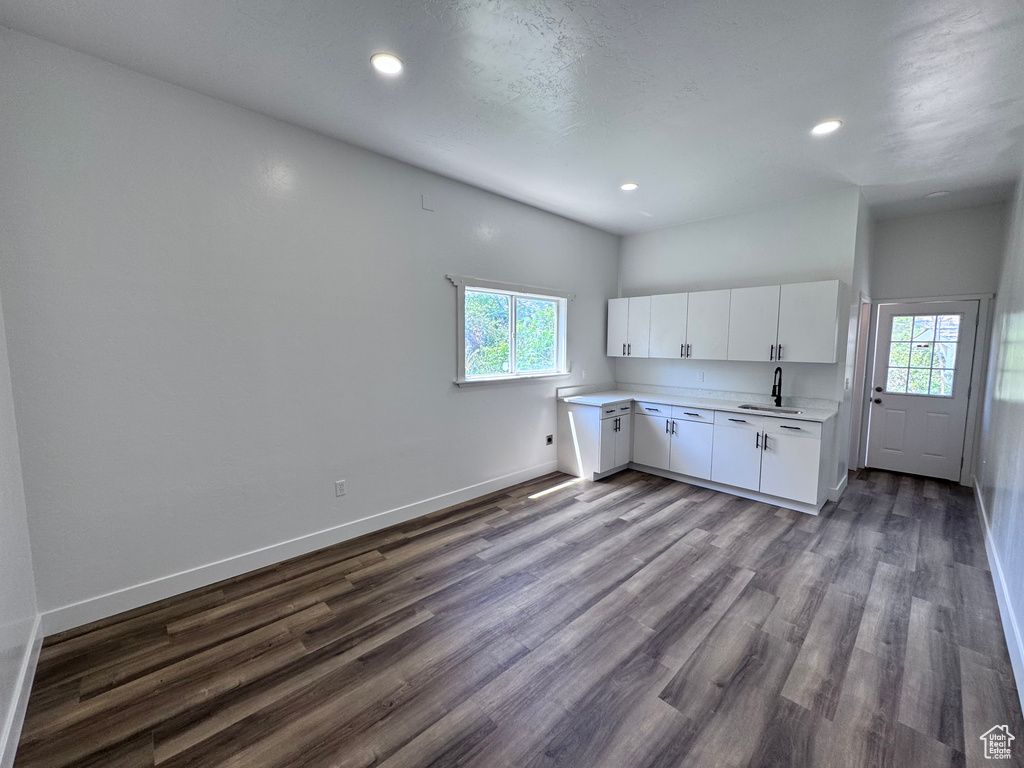 Kitchen featuring a sink, plenty of natural light, light countertops, baseboards, and recessed lighting