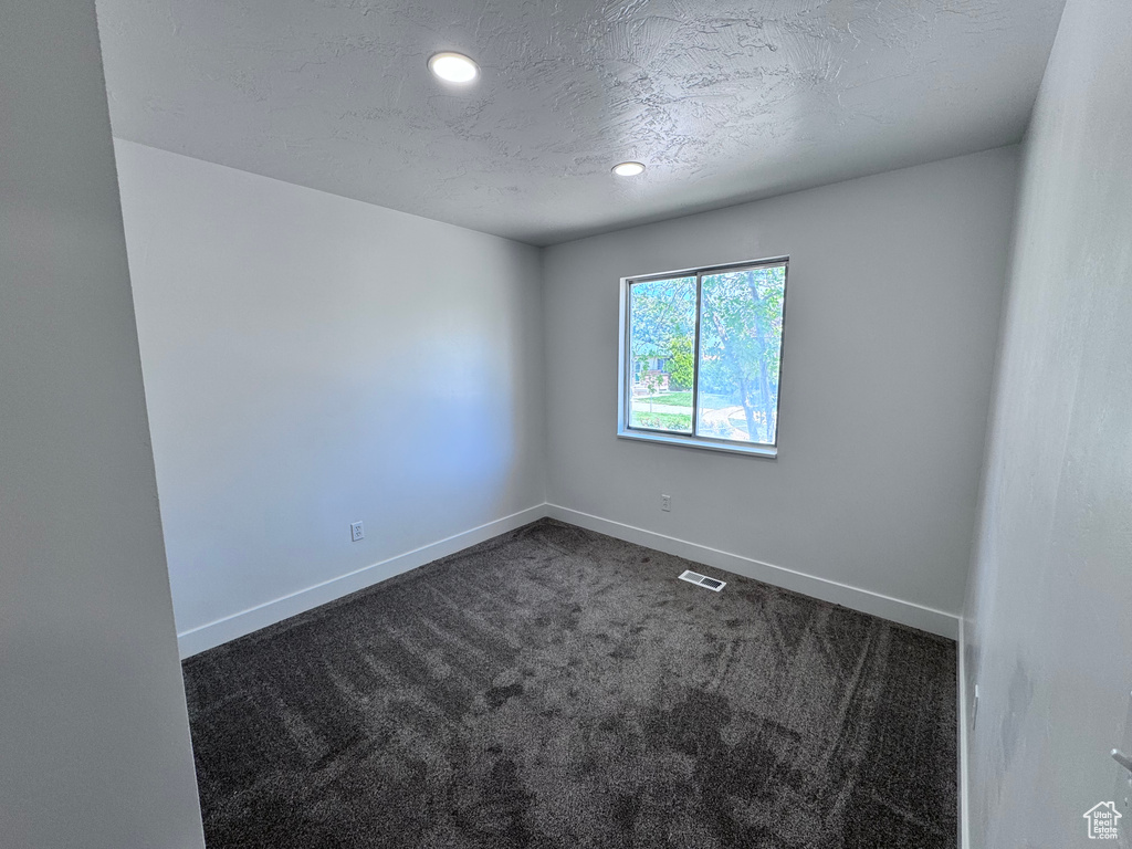 Unfurnished room with carpet, baseboards, a textured ceiling, and recessed lighting