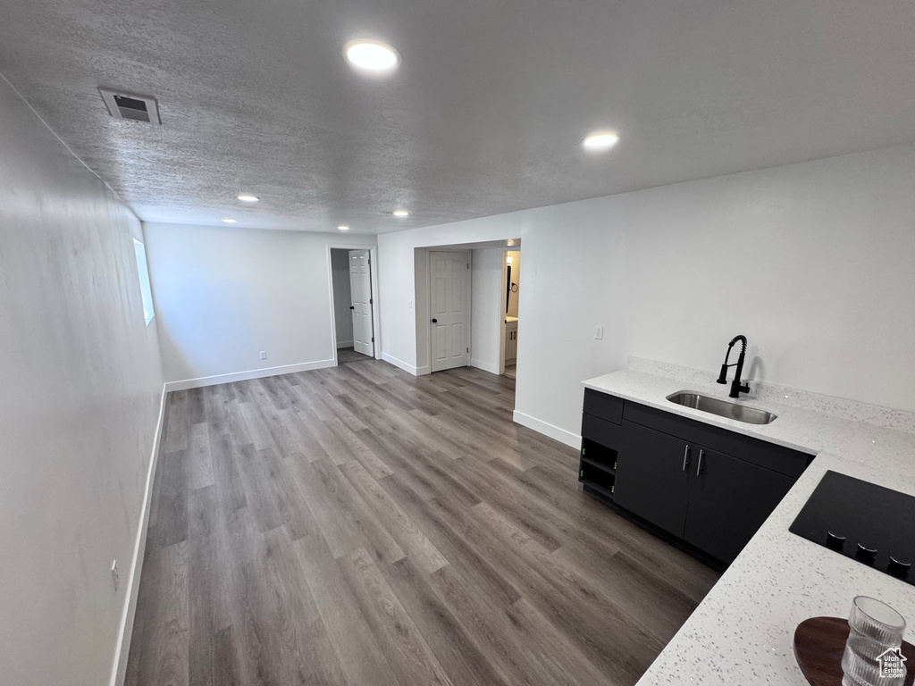 Bar with a sink, recessed lighting, baseboards, black electric stovetop, and wood finished floors