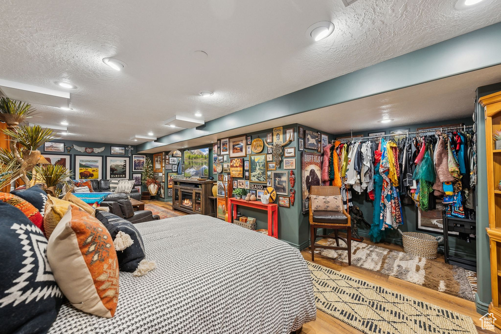 Bedroom with wood finished floors and a textured ceiling