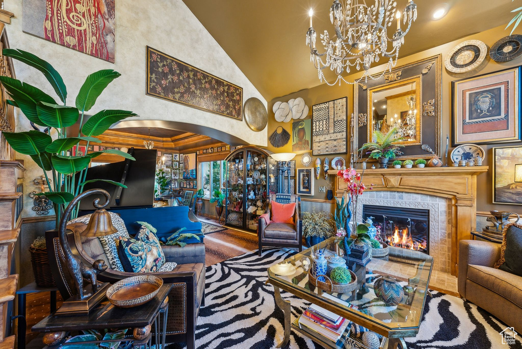 Living area featuring a chandelier, arched walkways, a high end fireplace, and high vaulted ceiling