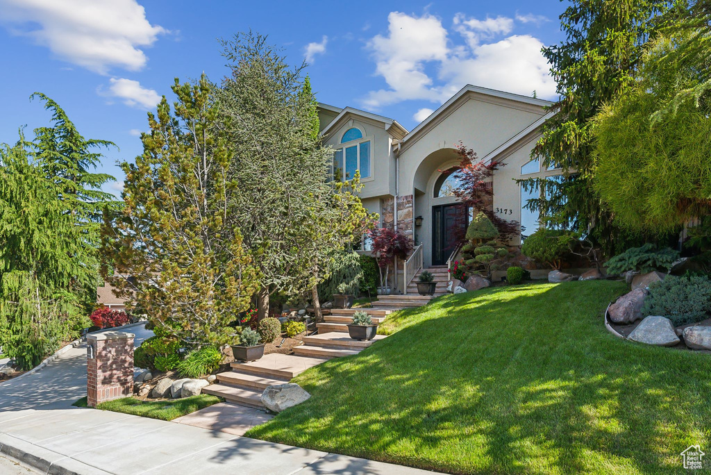 View of front of property featuring stucco siding and a front yard