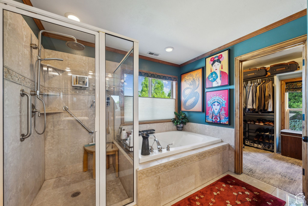 Bathroom with a garden tub, a shower stall, crown molding, a spacious closet, and tile patterned flooring