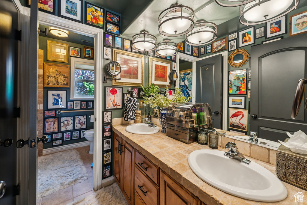 Bathroom with double vanity, toilet, and tile patterned floors