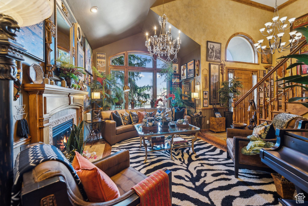 Living room featuring a chandelier, high vaulted ceiling, stairway, and a tiled fireplace