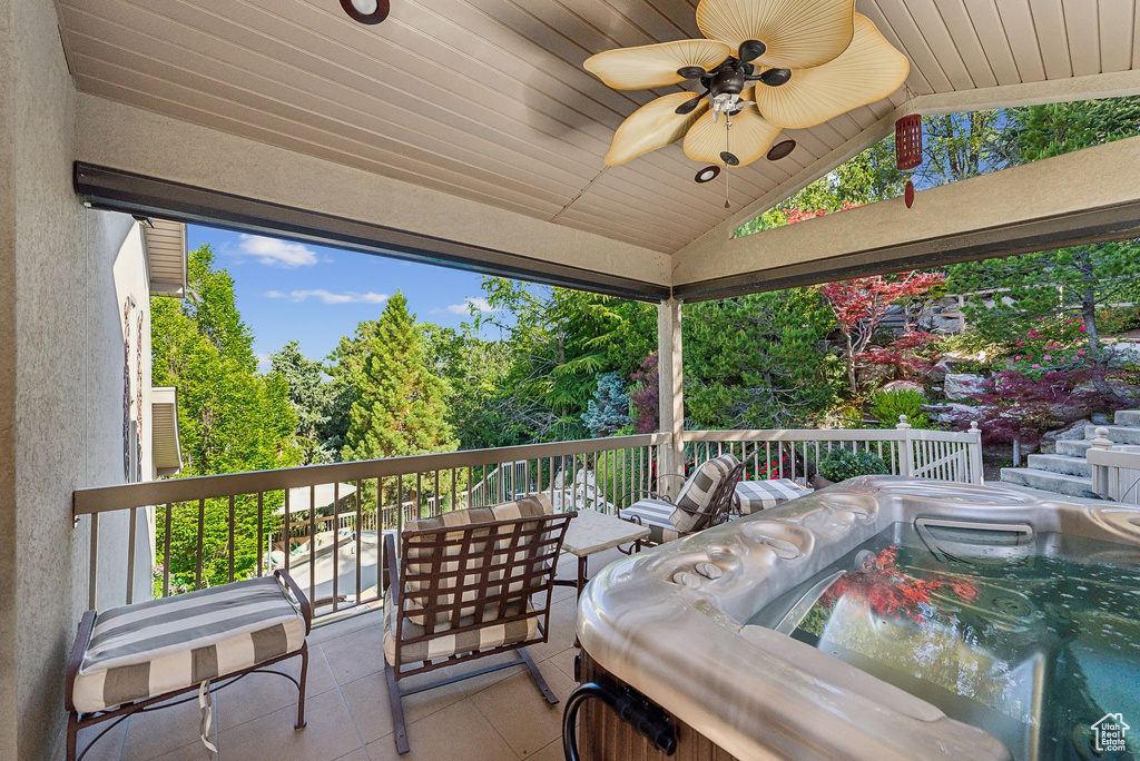 Wooden deck featuring a ceiling fan and view of wooded area