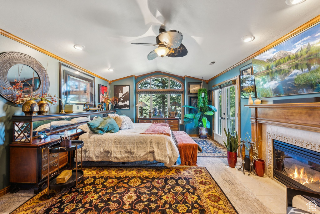 Bedroom featuring ornamental molding, a tiled fireplace, vaulted ceiling, baseboards, and recessed lighting