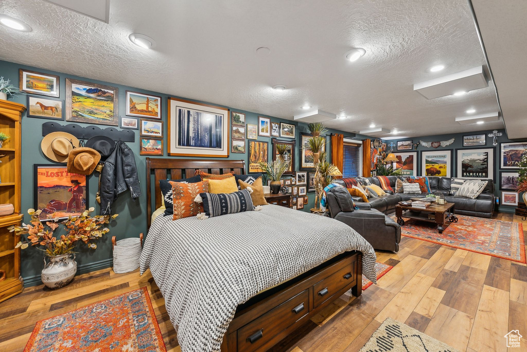 Bedroom featuring a textured ceiling, light wood-style floors, and recessed lighting