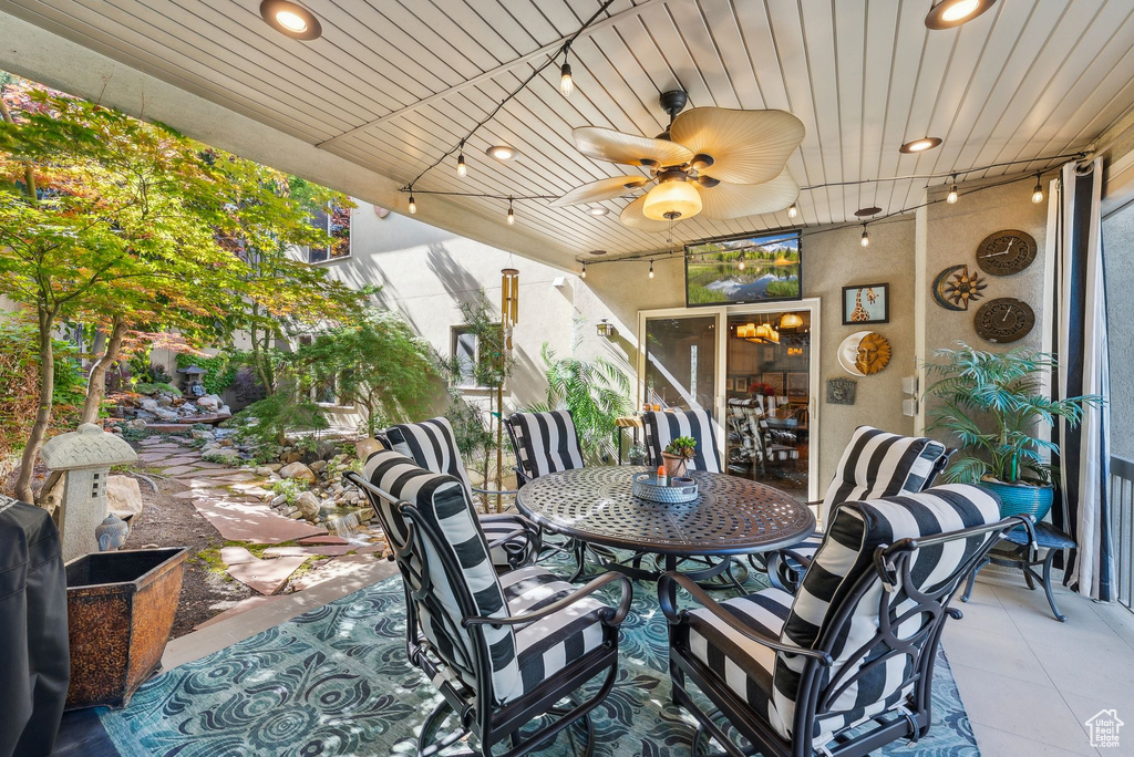 View of patio with outdoor dining area and ceiling fan