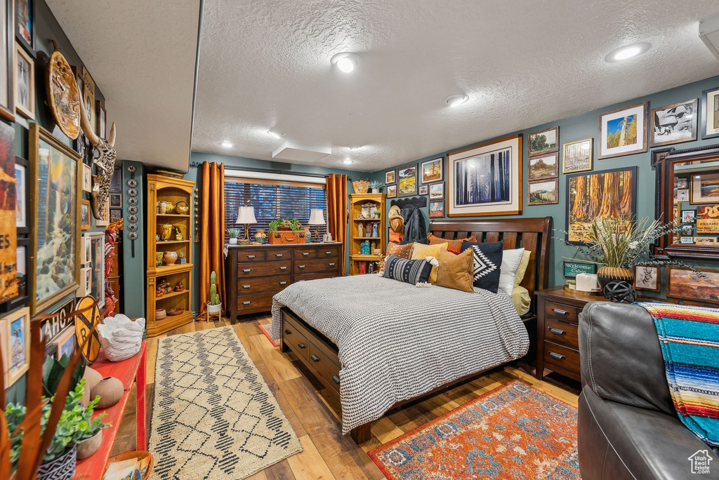 Bedroom with a textured ceiling and wood finished floors
