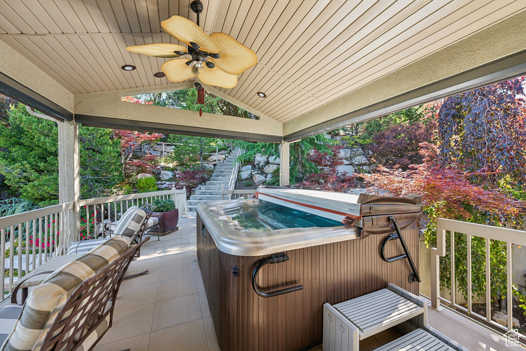 View of patio with a hot tub, ceiling fan, and stairway