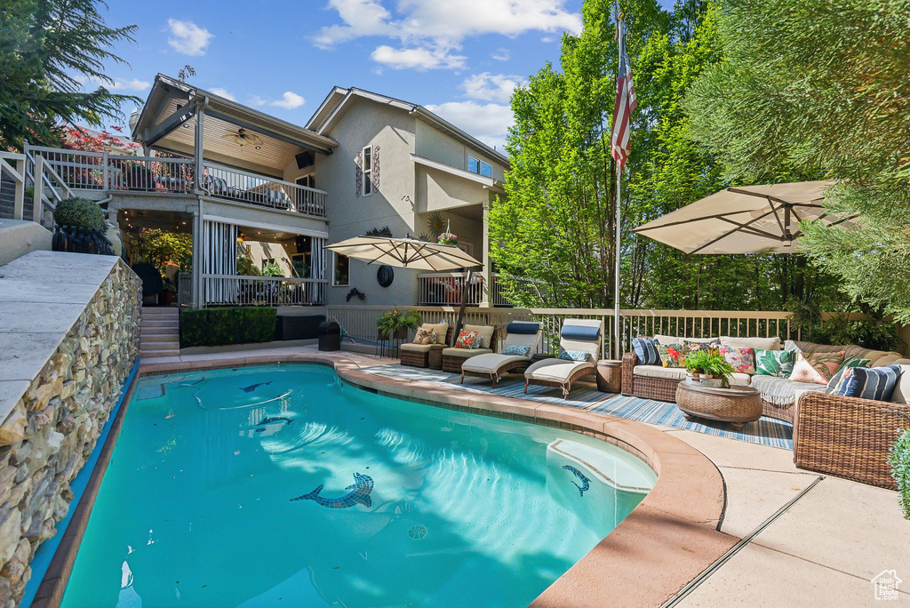 Outdoor pool with an outdoor hangout area, a ceiling fan, a deck, and a patio