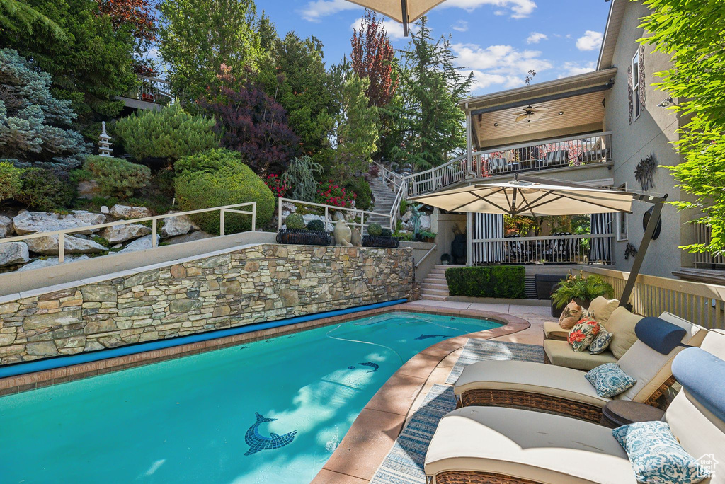 Outdoor pool with stairway, an outdoor living space, and a patio