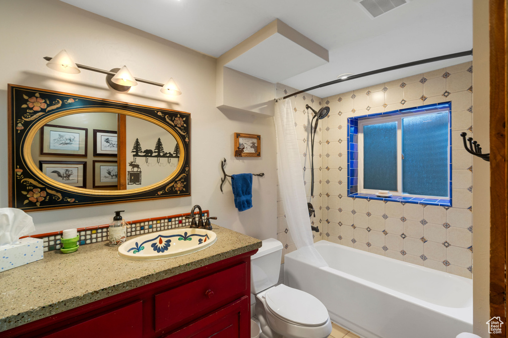 Full bath with toilet, shower / tub combo with curtain, and vanity