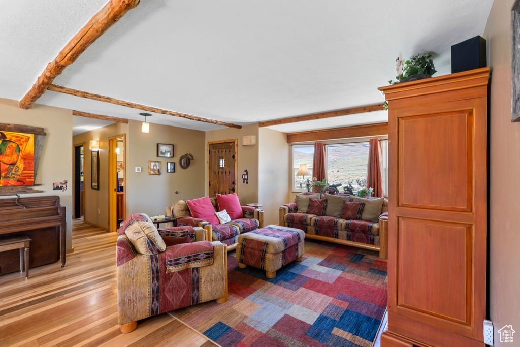 Living room featuring light wood finished floors and beam ceiling