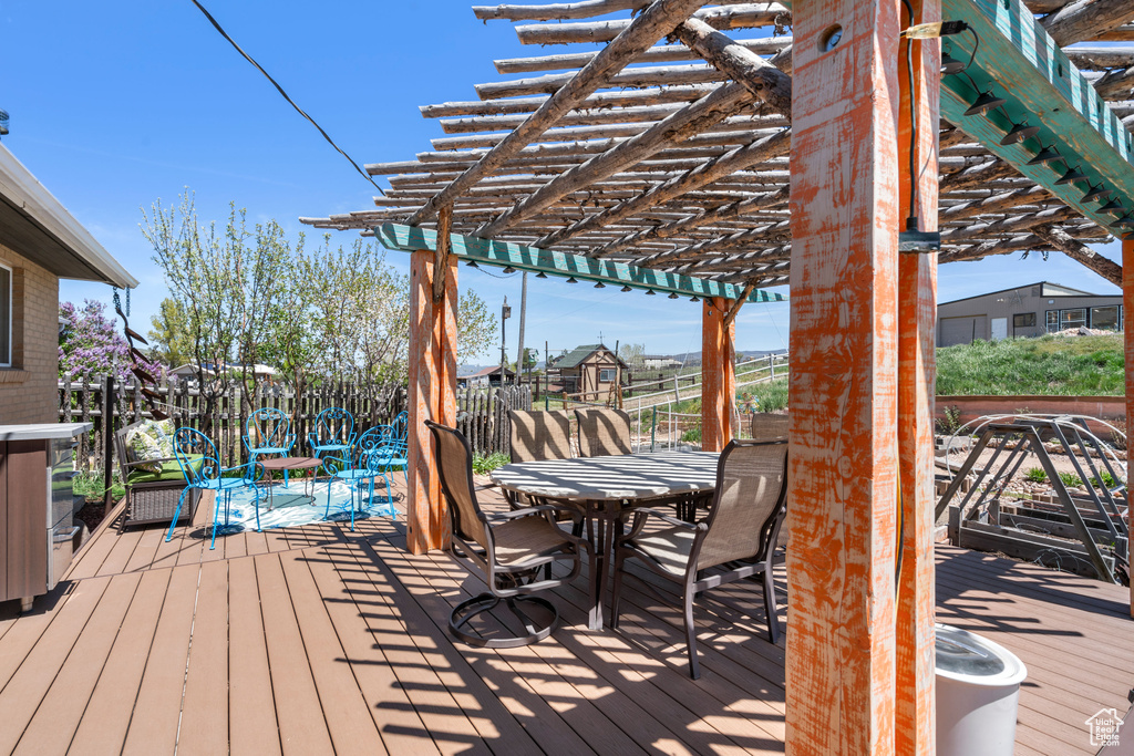 Wooden deck featuring a pergola and outdoor dining space