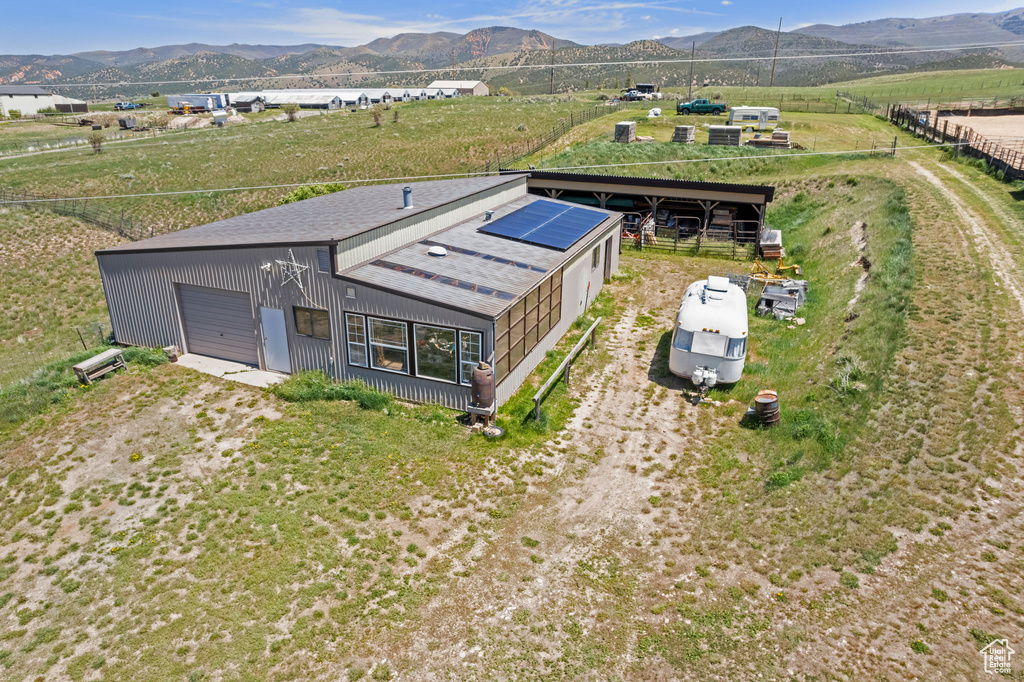 Aerial view of property and surrounding area with a mountain backdrop