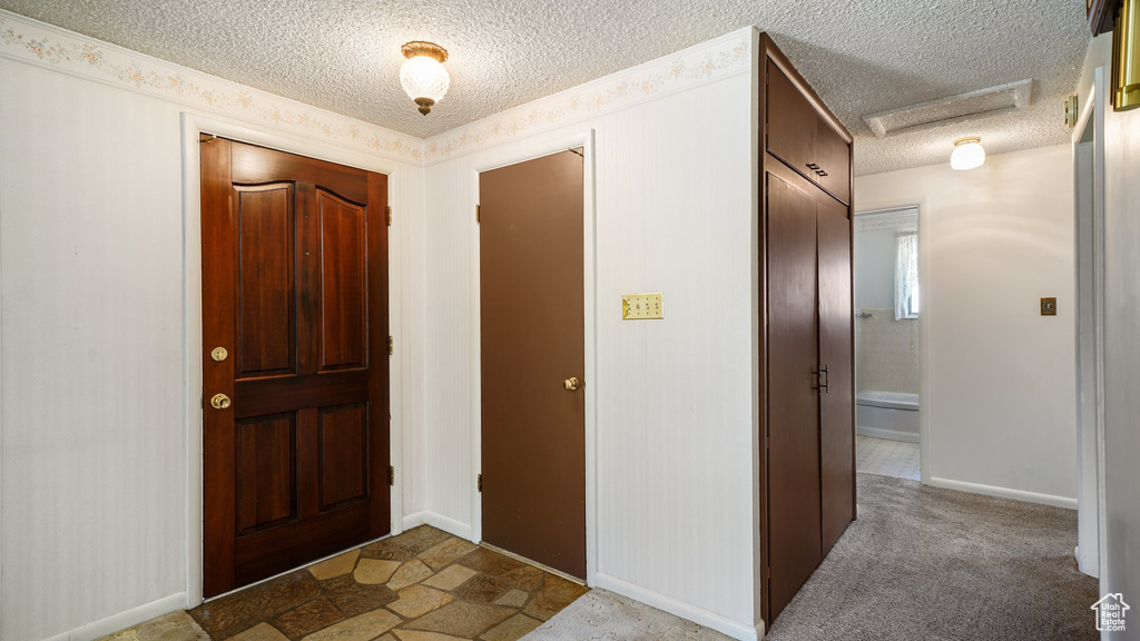 Entryway featuring a textured ceiling and baseboards