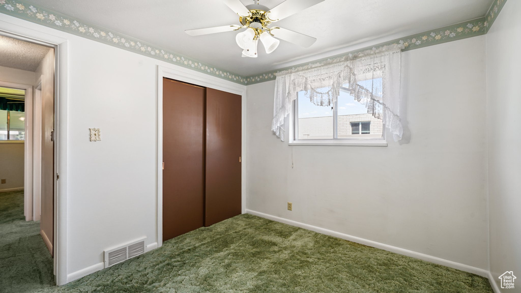 Unfurnished bedroom with carpet floors, a closet, baseboards, and a ceiling fan