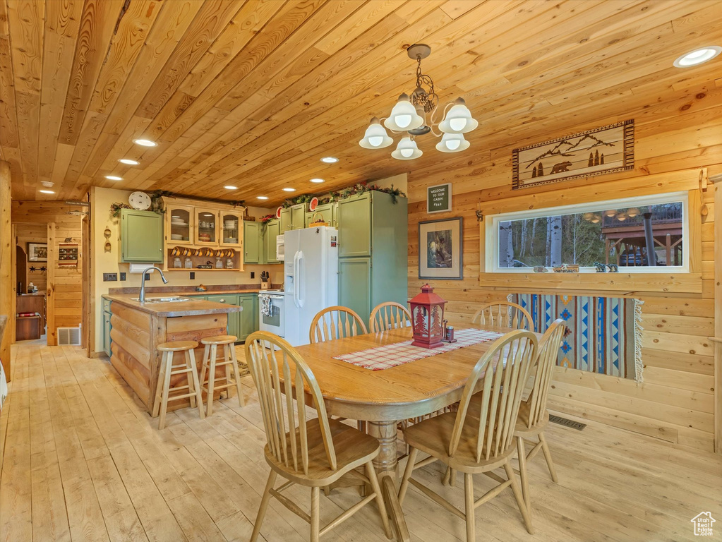Dining room with wood ceiling, wood walls, a chandelier, light wood-style flooring, and recessed lighting