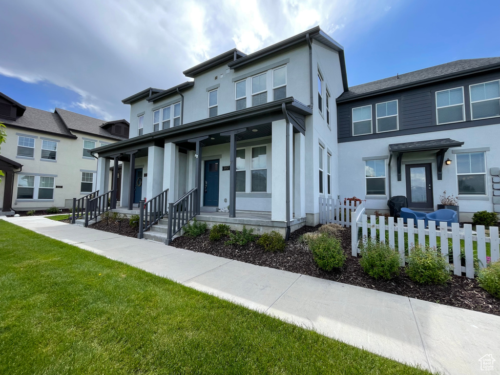 View of front of house with stucco siding and covered porch