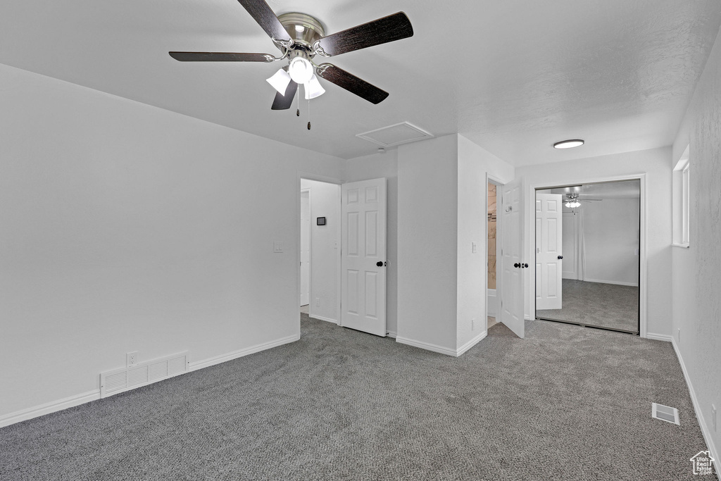 Unfurnished bedroom with carpet flooring, baseboards, a closet, ceiling fan, and attic access