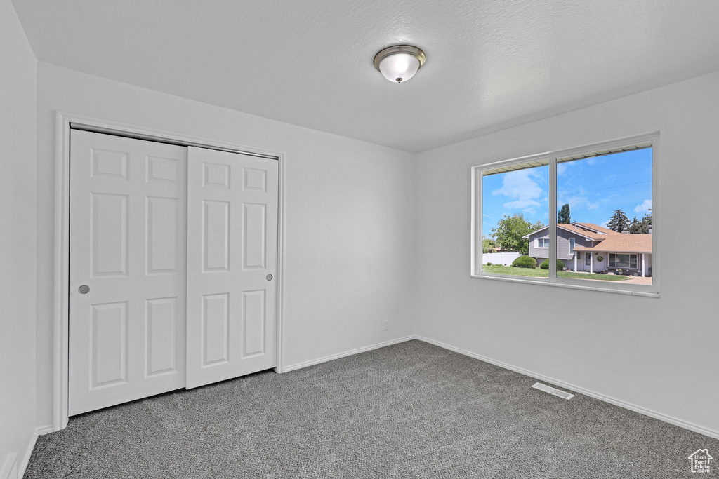 Unfurnished bedroom with carpet flooring, baseboards, and a closet