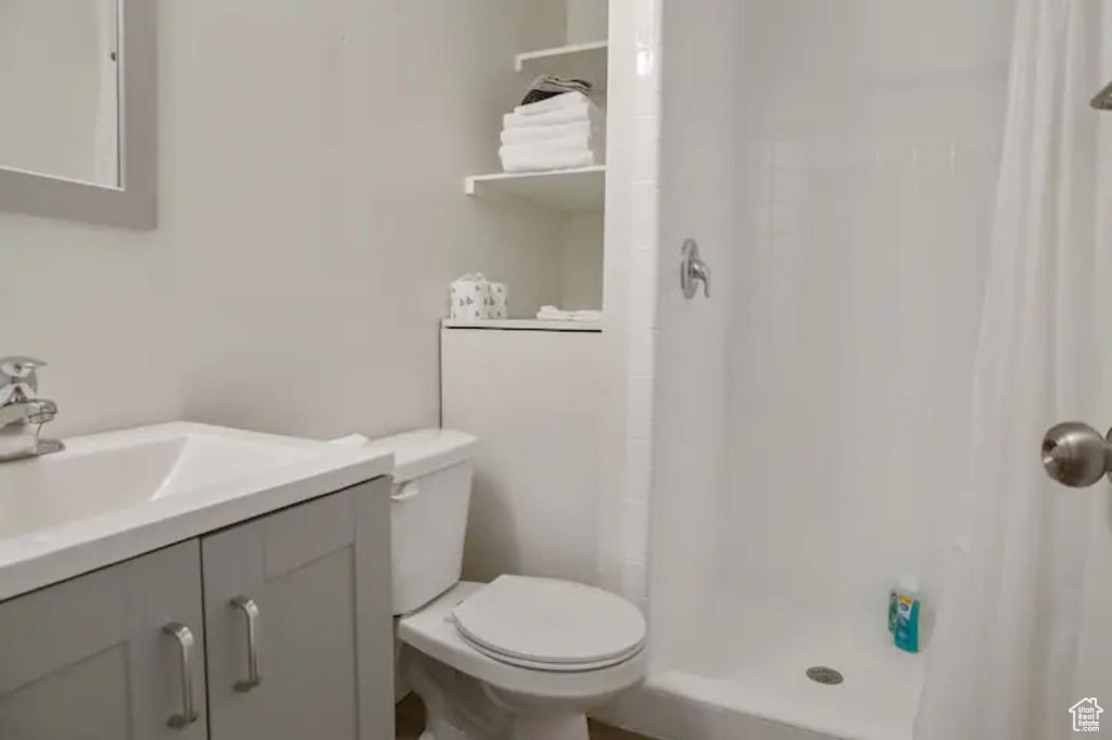 Bathroom with a shower with curtain, toilet, and vanity