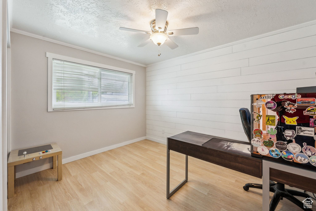 Office featuring wood finished floors, a ceiling fan, a textured ceiling, ornamental molding, and baseboards